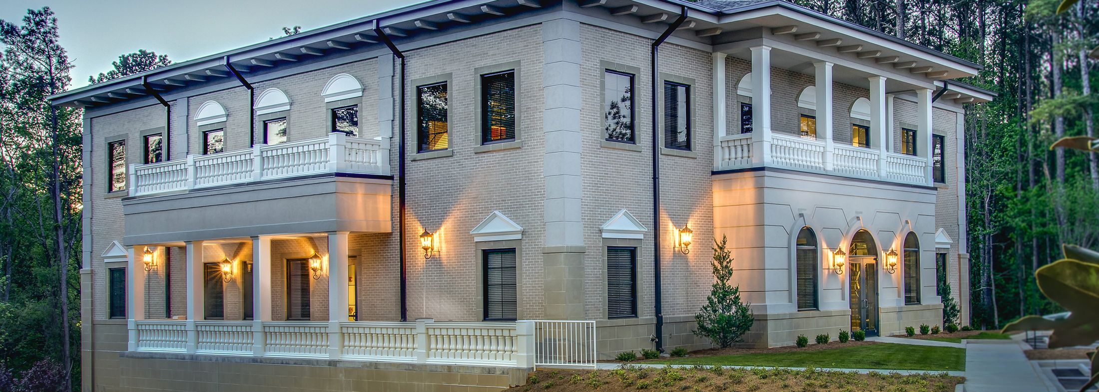 Elegant two-story house with columns and balcony.