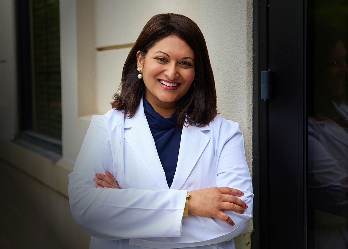 Smiling woman in a white lab coat.