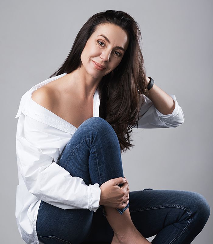 Woman in casual outfit, smiling at the camera.