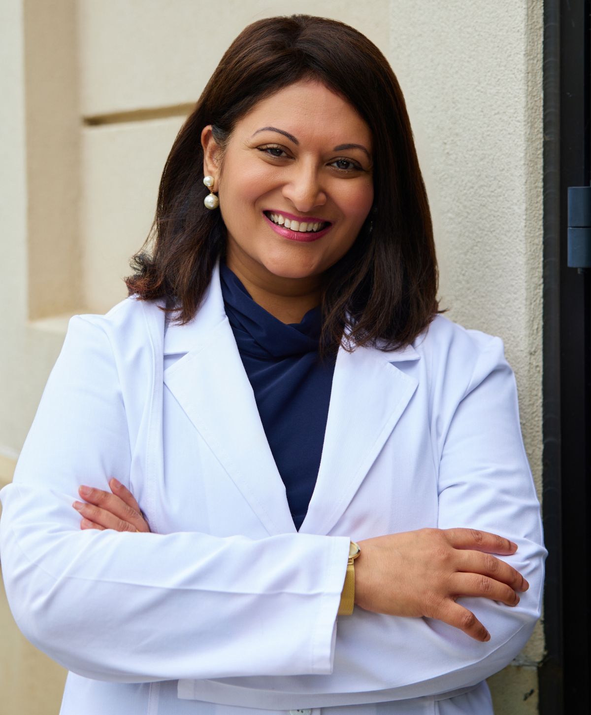 Smiling professional in white lab coat.