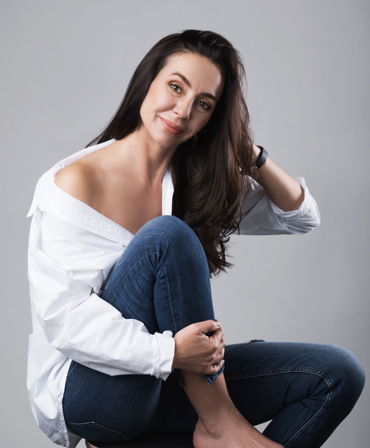 Alpharetta Laser Vaginal Rejuvenation model in white shirt, sitting with confident smile.