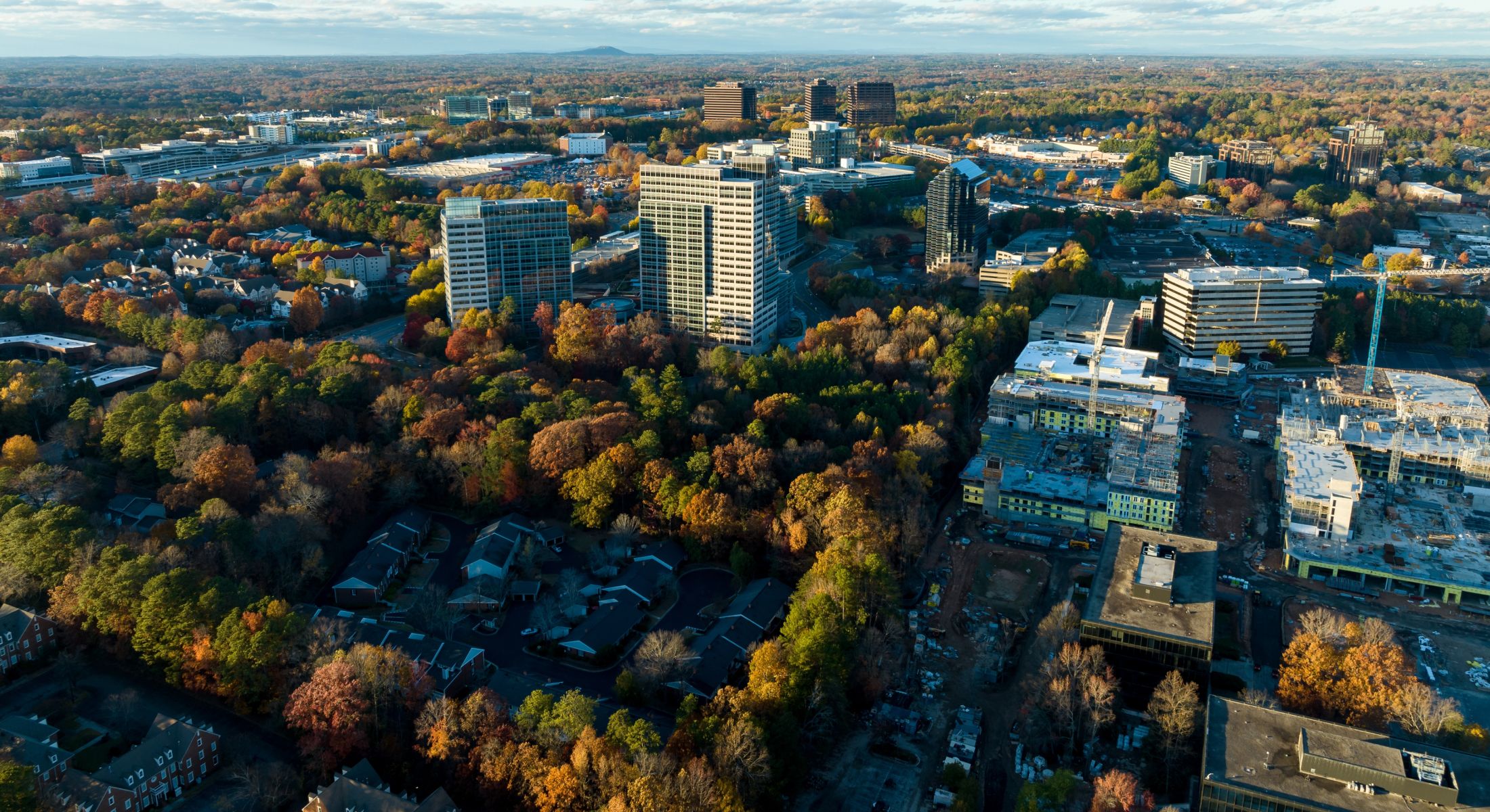 Aerial view of urban area surrounded by autumn trees.